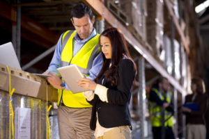 Illustrative image of a man and woman checking inventory levels in a warehouse.